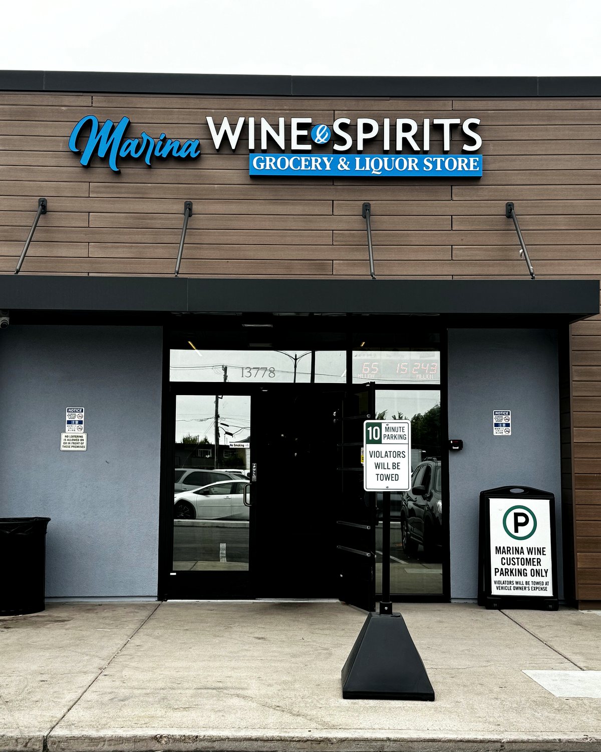 The Marina Wine & Spirits storefront at 13778 Doolittle Drive, with its blue and white sign reading Grocery and Liquor Store above the entrance.